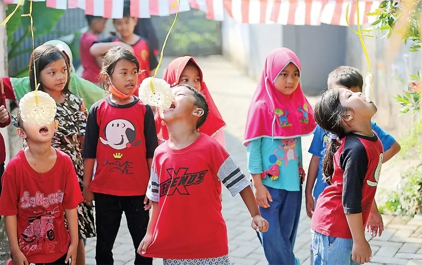 KRIUK: Sejumlah anak berpartisipasi dalam lomba makan kerupuk yang diselenggarakan oleh dan untuk kalangan keluarga sendiri di Bekasi.