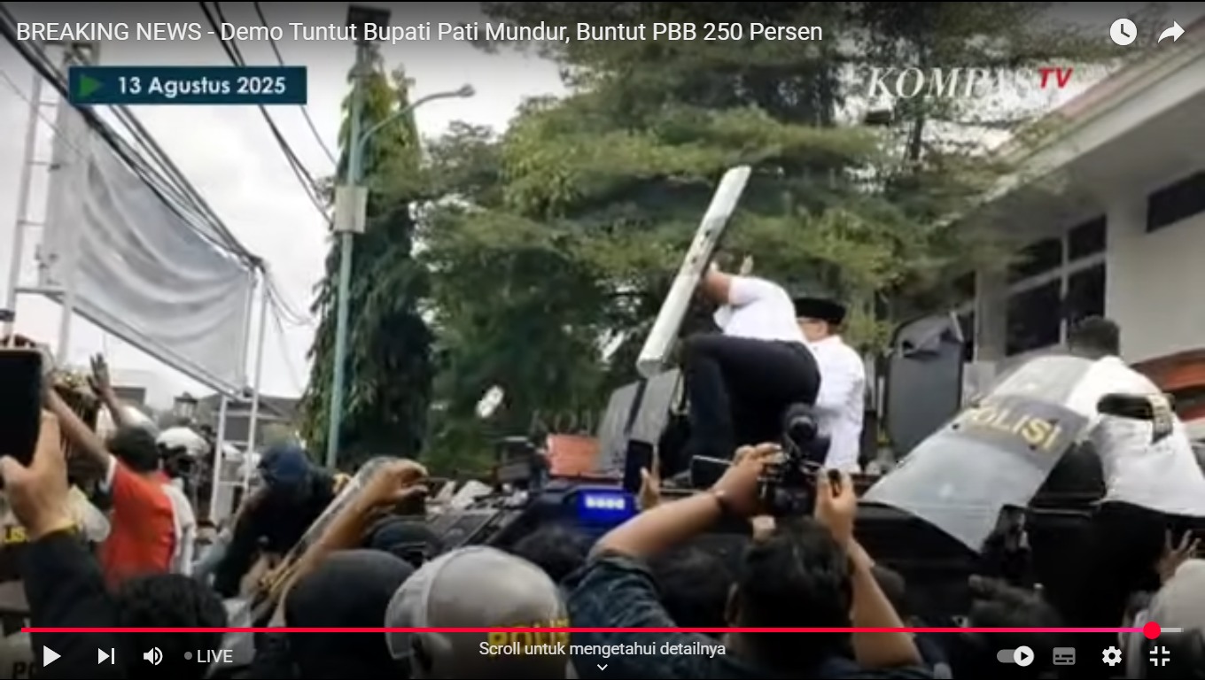 Petugas kepolisian melindungi Bupati Pati Sudewo dengan tameng yang hendak menyapa massa, Rabu (13/8/2025).