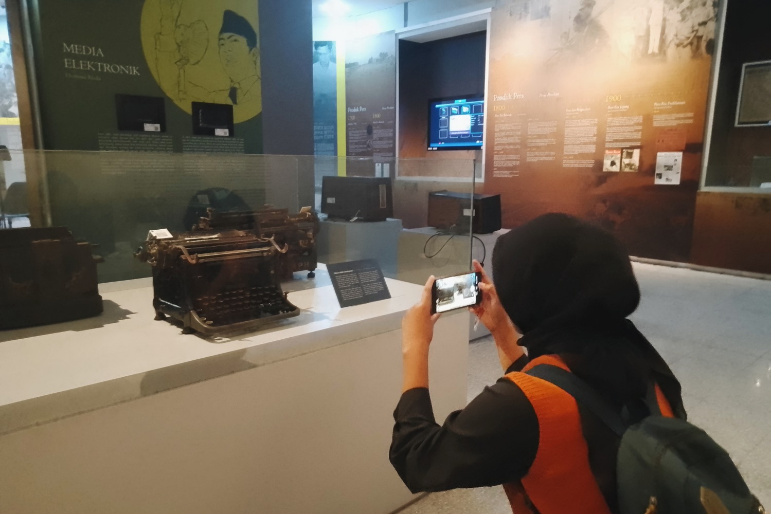 Ella (21) sedang memotret mesin ketik yang paling tua di museum Monumen Pers, Jumat (15/8/25).