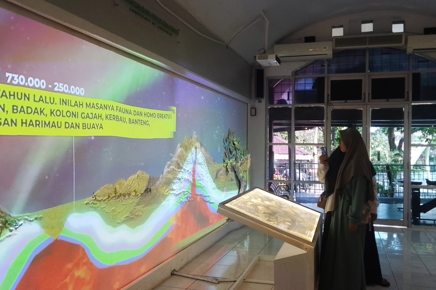 Pengunjung yang sedang mengakses media interaktif asal mula Sangiran yang disediakan oleh Museum Manusia Purba Sangiran Klaster Krikilan, Kalijambe, Sragen, Rabu (27/8/25)