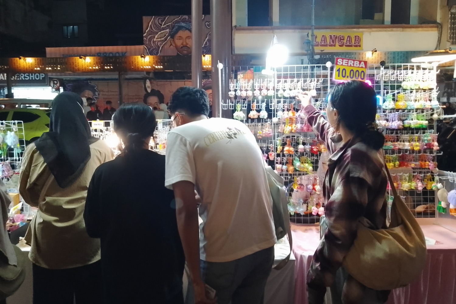 Pengunjung sedang memilih produk Street Art Market yang dijajakan di koridor Gatot Subroto, Sabtu (6/9/2025)