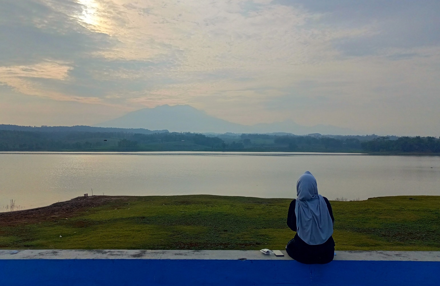 Pengunjung sedang duduk di tepi tanggul Waduk Delingan, Karanganyar, Rabu (17/09/25).