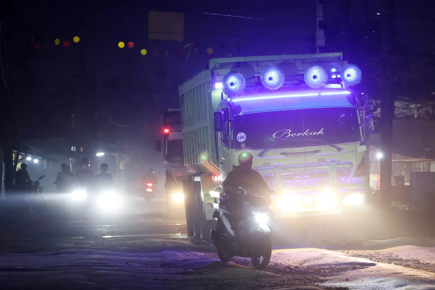 Pengguna sepeda motor melintasi jalur yang di lewati truk tambang yang menyebabkan kemacetan di Parung Panjang, Bogor, Jawa Barat.