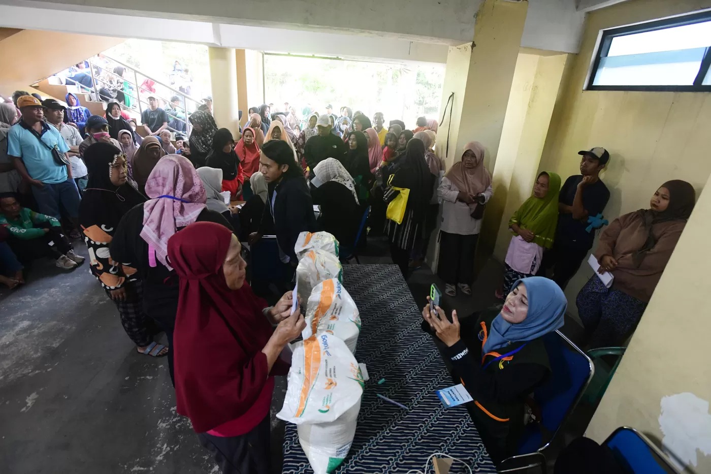 Keluarga Penerima Bantuan Pangan (PBP) antri untuk menerima Bantuan Pangan Non Tunai (BPNT) beras 20 kg di Kantor Kelurahan Rangkapan Jaya Baru, Depok, Jawa Barat, Kamis, (24/07/2025).