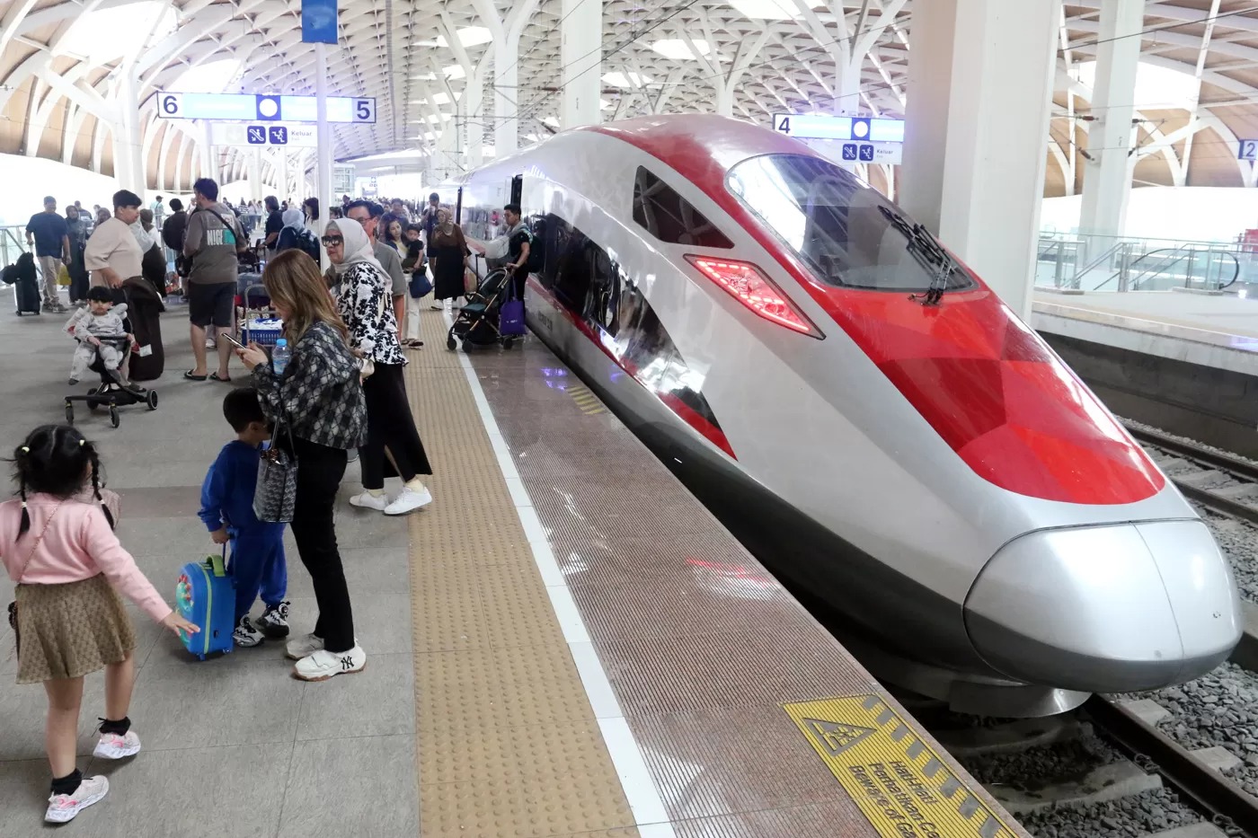 Penumpang berjalan keluar saat tiba di Stasiun Kereta Cepat Whoosh Halim, Jakarta, Sabtu (5/4/2025).
