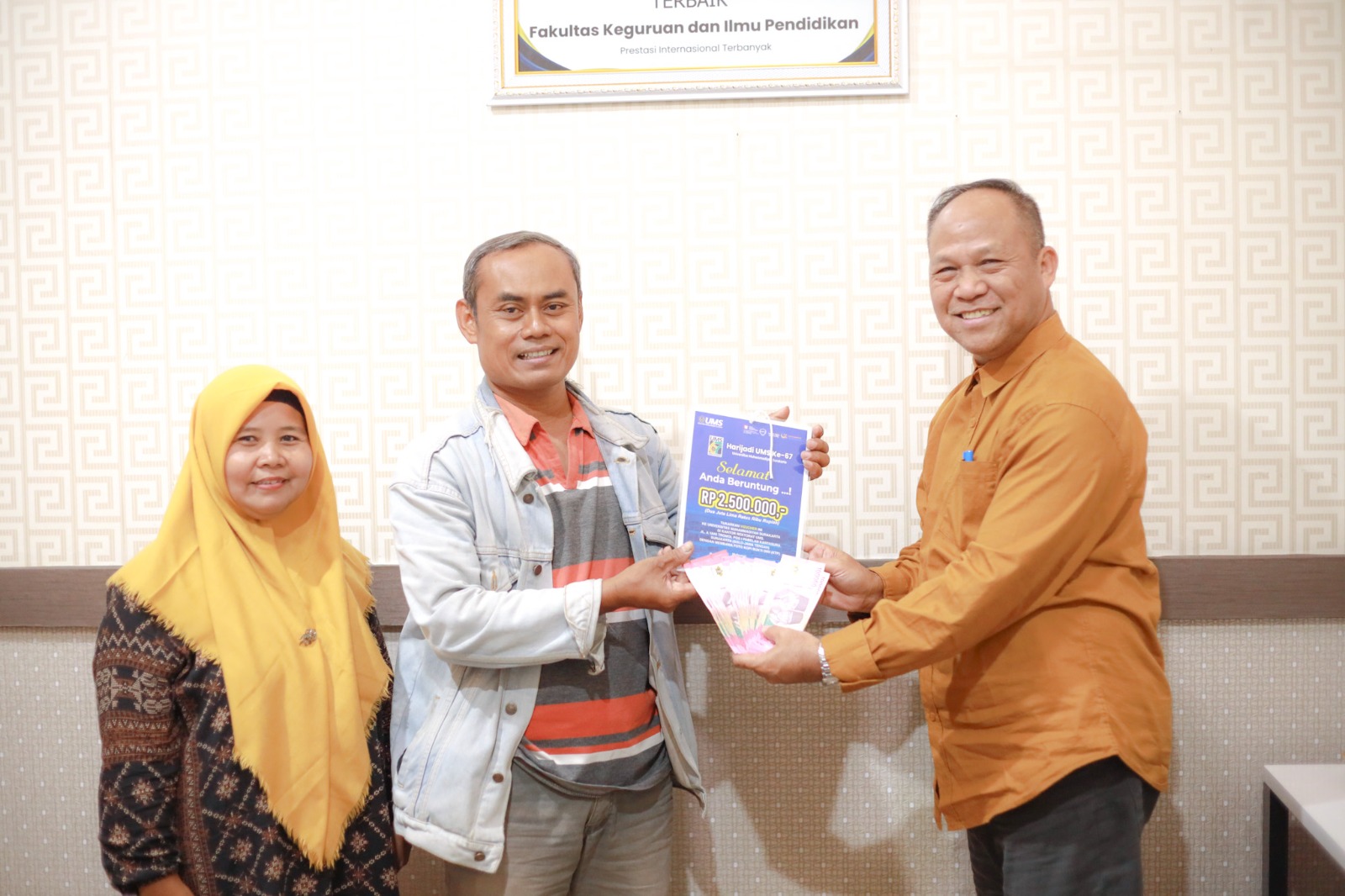 Panitia Hari Jadi ke-67 UMS, Anam Sutopo (kanan) menyerahka hadiah kepada pemenang  dari Gunung Kidul yang menemukan hadiah balon udara, berisi voucher senilai Rp 2.5 juta.