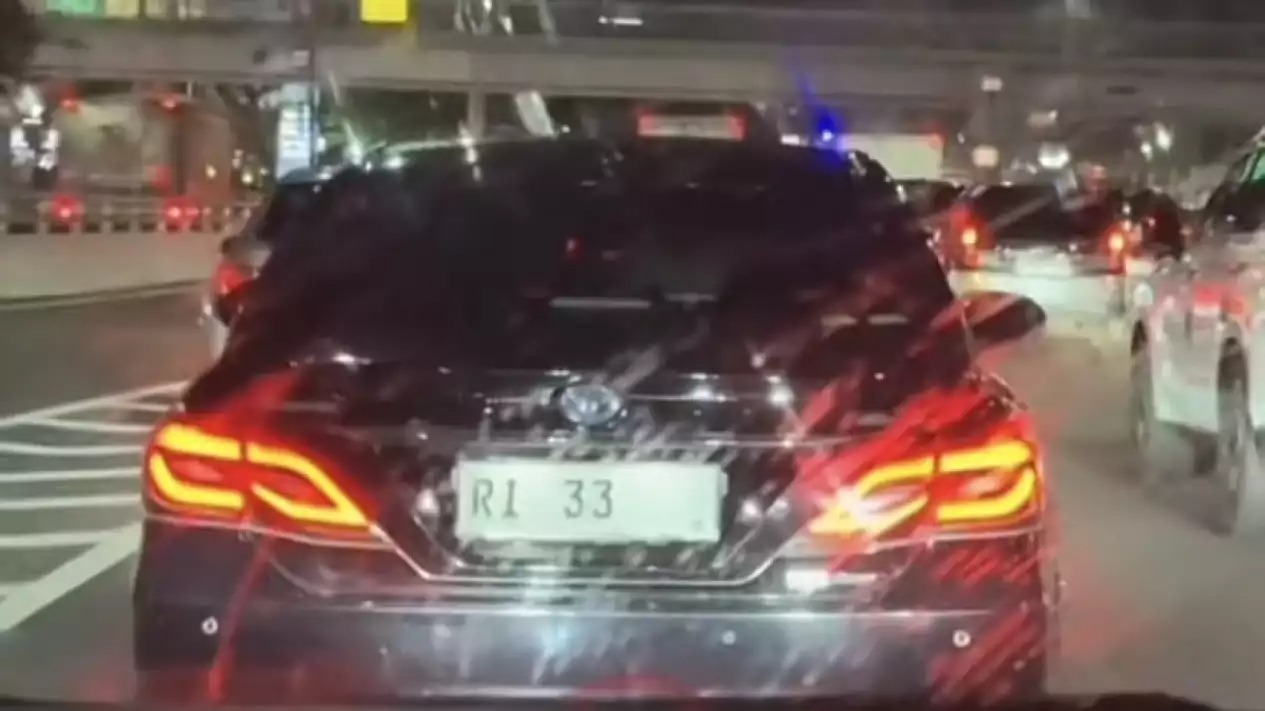 Mobil dinas berpelat nomor RI 33 di tengah jalan macet tanpa pengawalan.