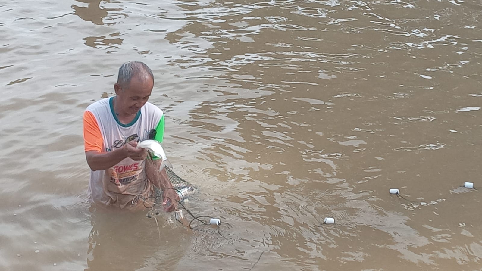 Warga menangkap ikan di sungai yang mulai surut airnya.