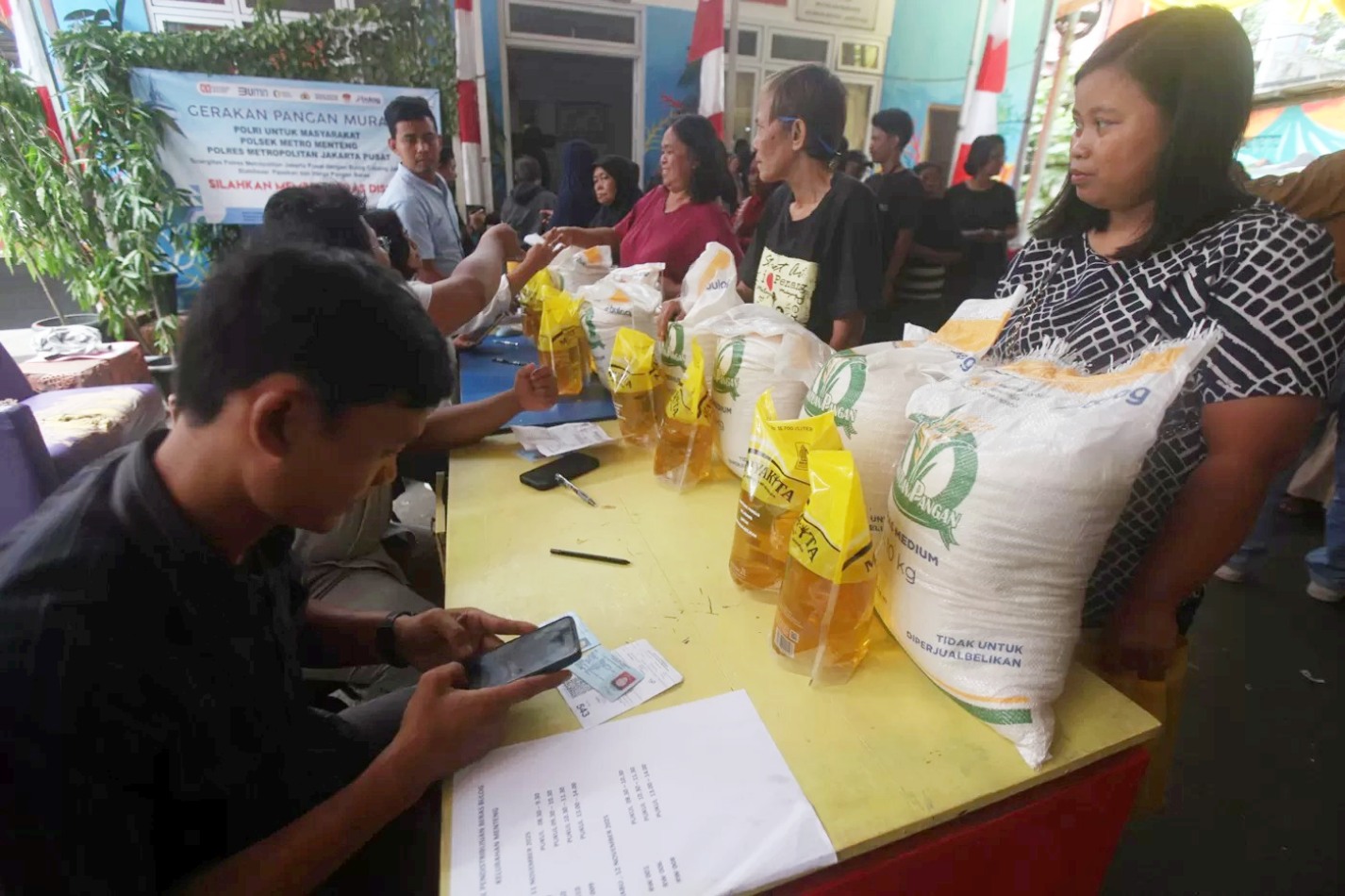 Warga saat pengambilan bantuan pangan gratis berupa beras dan minyak goreng di Balai RW 03 Menteng, Jakarta Pusat, Rabu (12/11/2025).