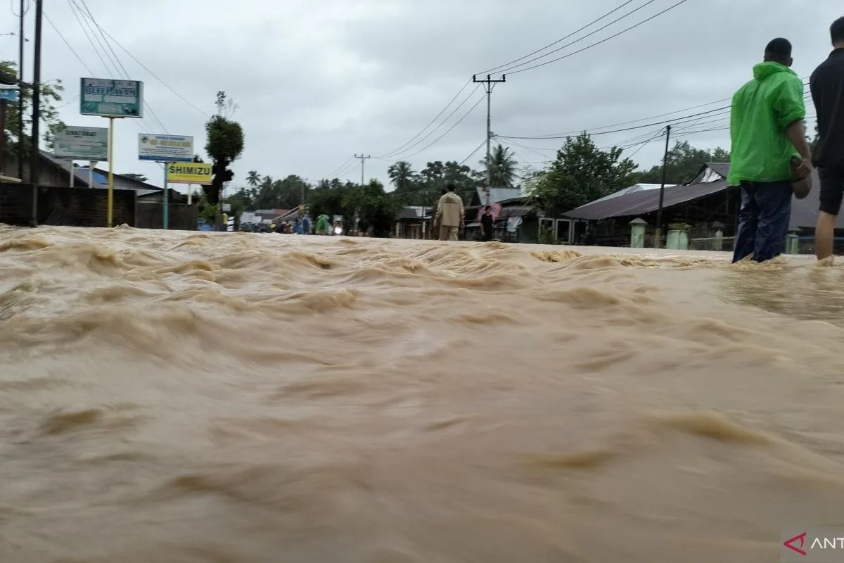Sejumlah warga lokal membantu mengarahkan pengendara jalan untuk berputar arah imbas banjir di daerah Pasar Usang, Kecamatan Batang Anai, Kabupaten Padang Pariaman, Kamis (27/11/2025).