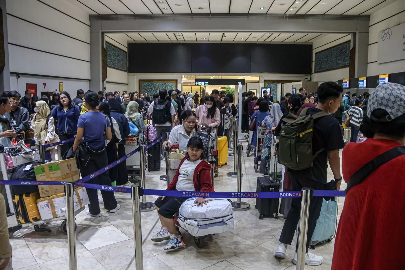 Penumpang mengantri di depan konter check-in di Terminal 2, Bandara Soekarno-Hatta, Tangerang, Sabtu (20/12/2025). Harga tiket pesawat di akhir tahun diskon hingga 14 persen.