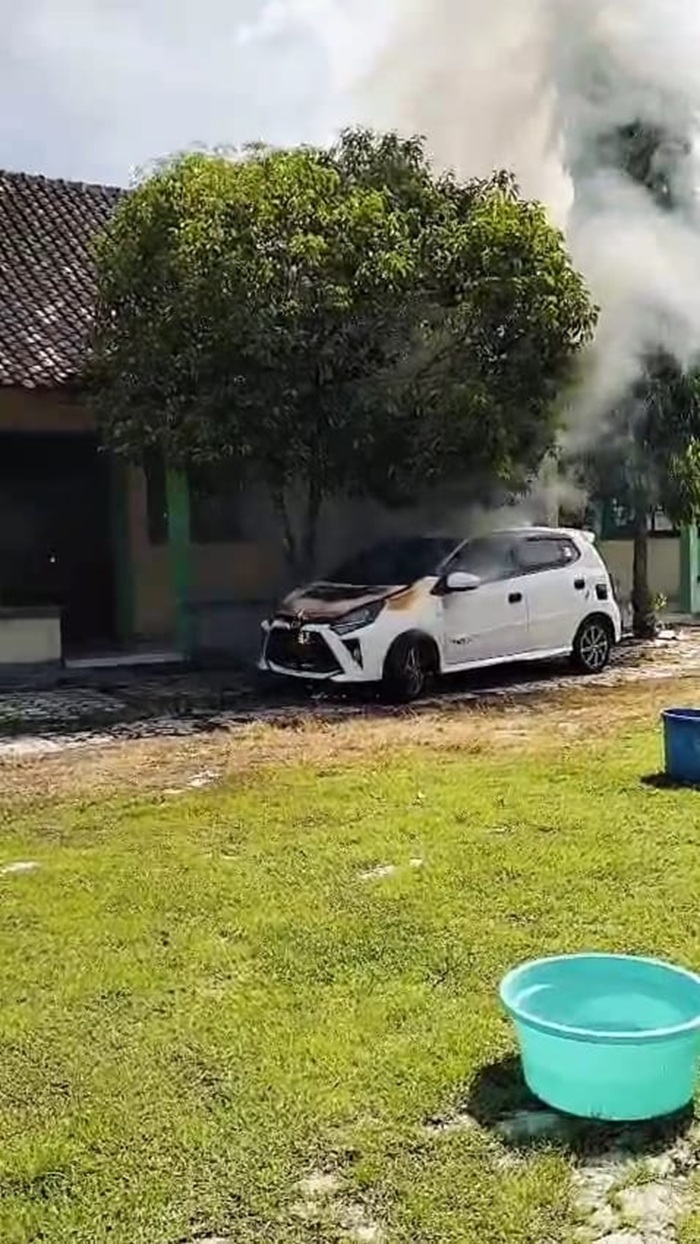 Mobil Toyota Agya milik Kepala SMK Kosgoro 2 Sragen terbakar di halaman sekolah.