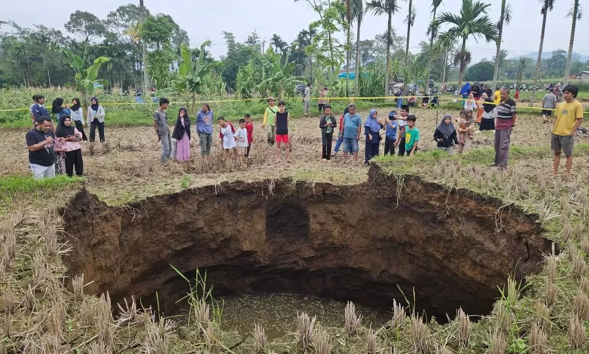Warga sekitar mendekati sinkhole yang mendadak muncul di wilayah Kabupaten Lima Puluh Kota, Sumbar.