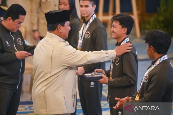 Presiden Prabowo Subianto didampingi Menpora Erick Thohir menyerahkan secara simbolis buku tabungan kepada atlet skateboard Basral Graito saat penyerahan bonus atlet peraih medali SEA Games Thailand 2