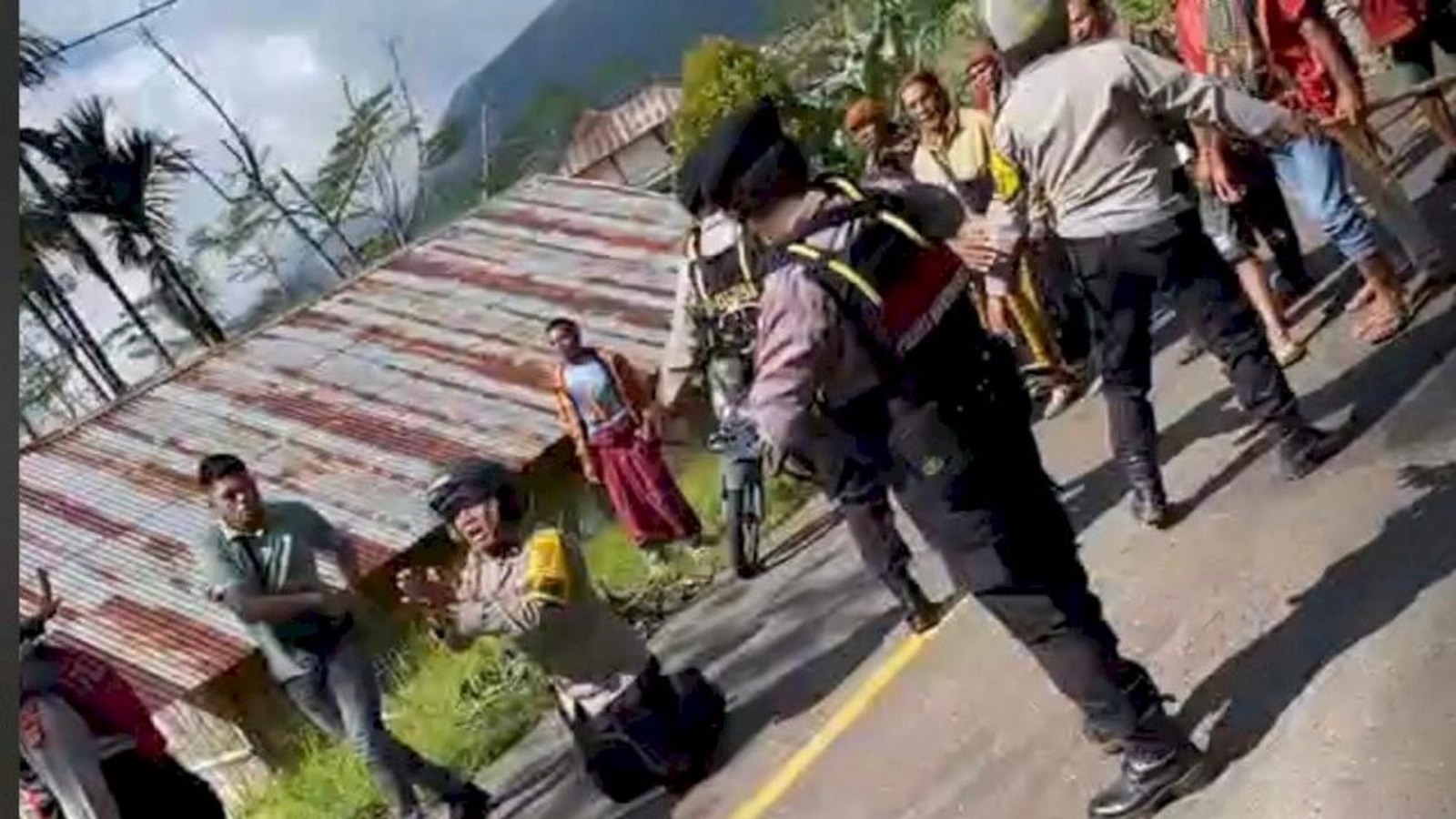 Anggota Polisi NTT Aipda Arkadius Modestus Arno berlutut di tengah massa bentrok.