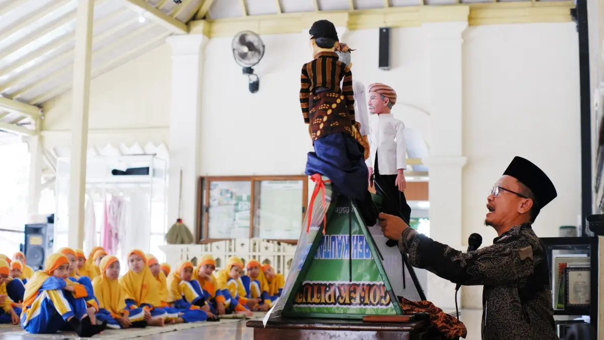 BUDAYA : Ki Pujiono, dalang wayang golek saat menampilkan ketrampilannya di depan anak-anak.