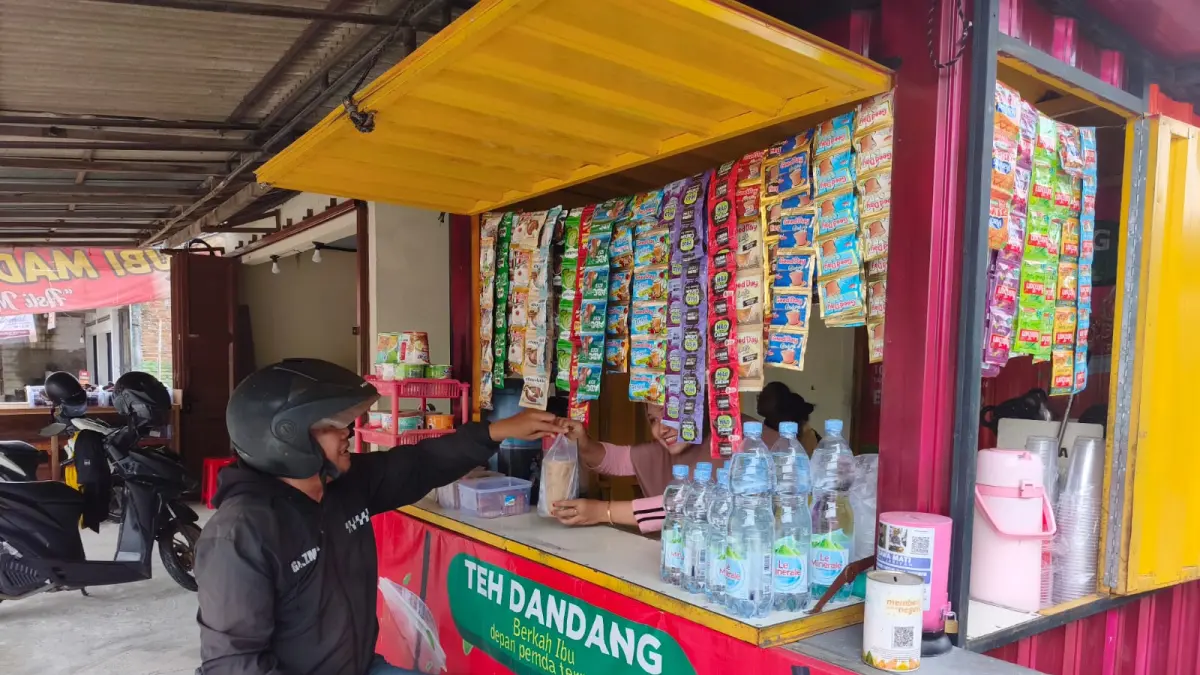 NAIK HARGA : Seorang warga membeli minuman dalam bungkus plastik di Sragen. (AHMAD KHAIRUDIN/SOLOBALAPAN.COM)