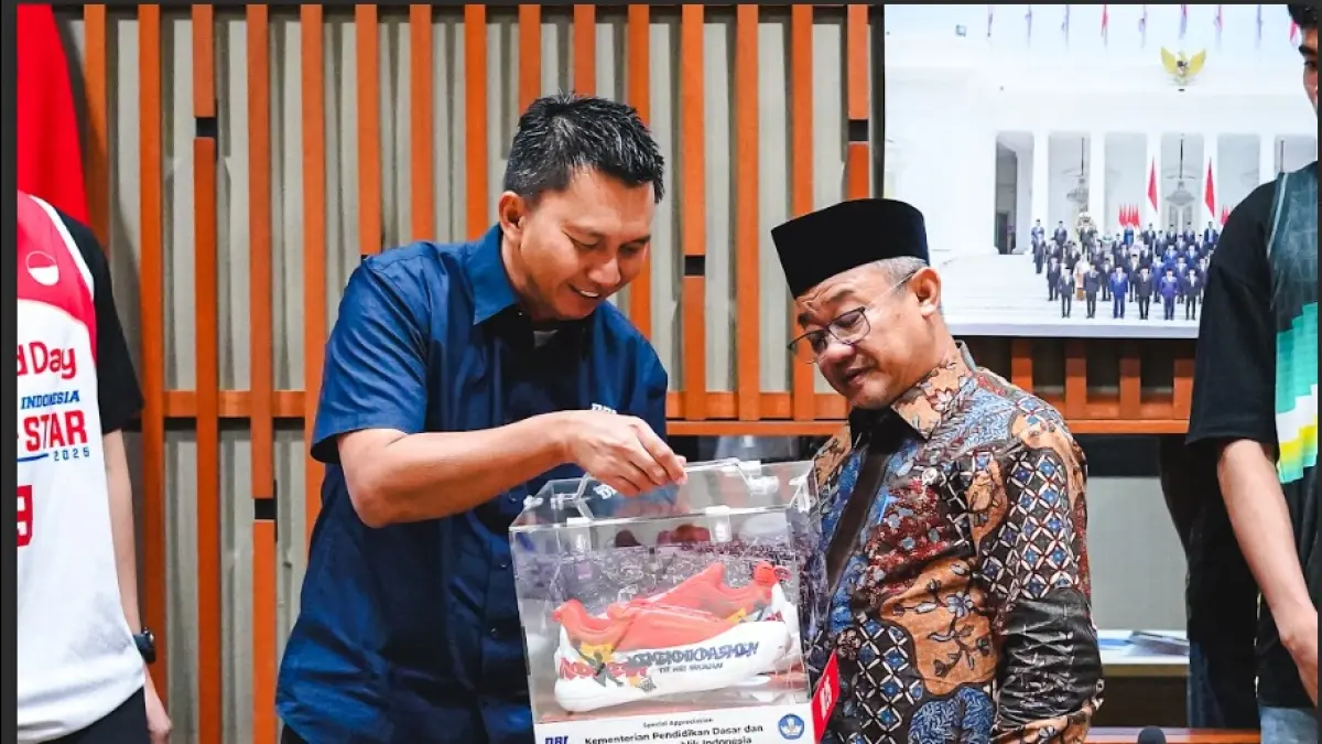 Azrul Ananda menyerahkan cinderamata berupa sepatu DBL Play 2.0 custom bertema pendidikan kepada Kemendikdasmen. (Dok. DBL)