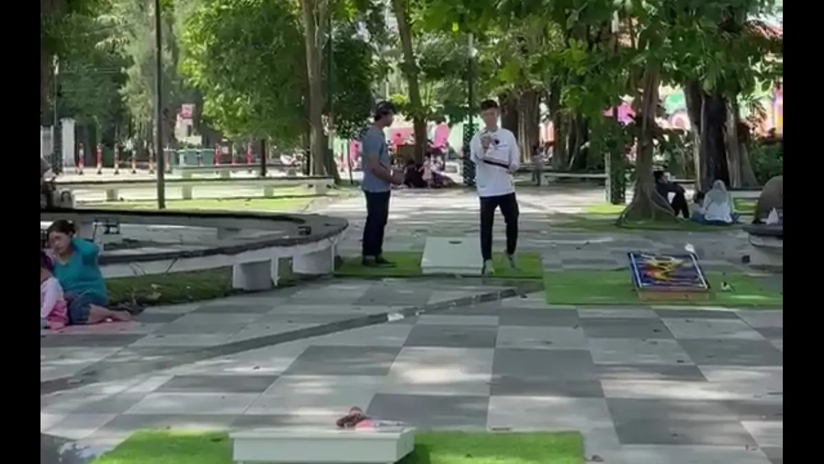 Orang bermain corn hole di Taman Manahan. 