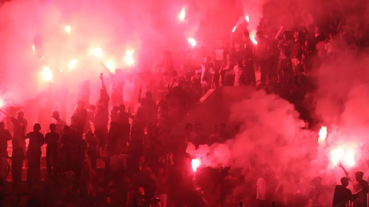 Suporter Persis Solo menyalakan flare usai tim kebanggaannya melawan Dewa United di Stadion Manahan (16/5/2026). (M. IHSAN/RADAR SOLO)