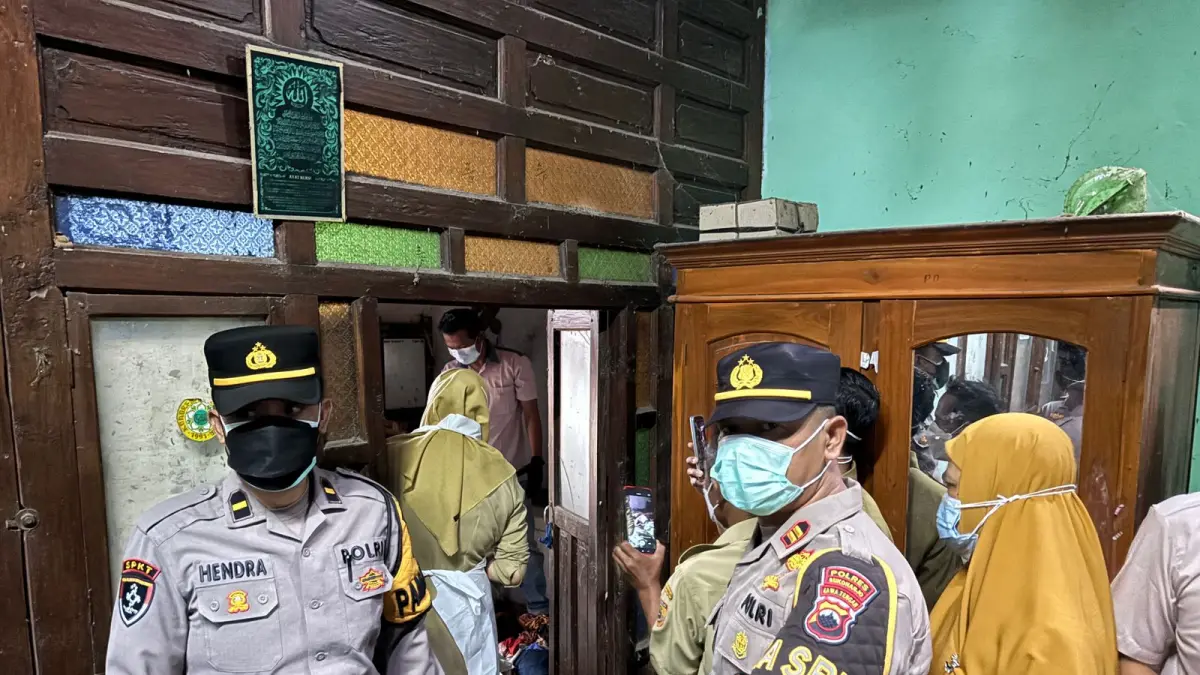Petugan melakukan pemeriksanan mayat yang membususk di dalam kamar. (IST)