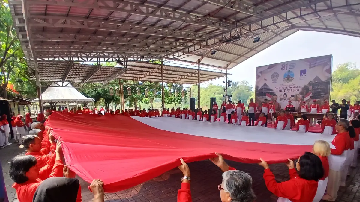 Momen haru lansia purnatugas PNS Pemkot Solo bentangkan Bendera Merah Putih raksasa di Taman Sunan Jogo Kali Pucangsawit, Senin (17/8/2026). (Damianus Bram/Solo Balapan)