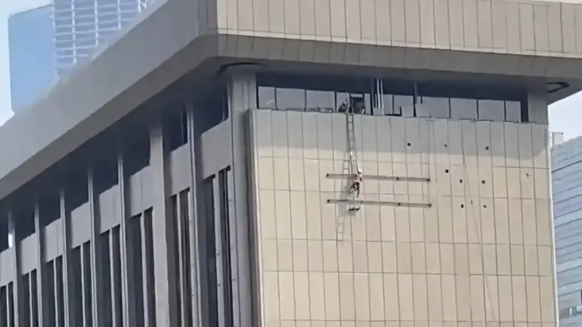 Seorang pekerja diduga mencopot logo Bank Mandiri di gedung bank tersebut yang berlokasi di Jakarta Pusat. (X @bismillahyuk_)