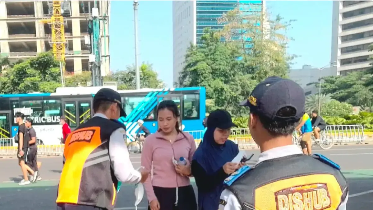 Petugas Dishub DKI mengimbau dan membagikan masker saat CFD Jakarta Minggu (6/9), imbas abu vulkanik erupsi Gunung Anak Krakatau. (Istimewa)