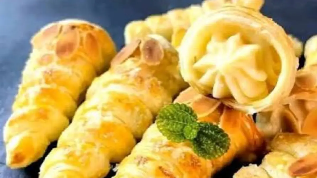 Kue cum-cum berbentuk kerucut dengan lapisan pastry renyah dan isian vla manis di bagian tengah.(BukuResep)