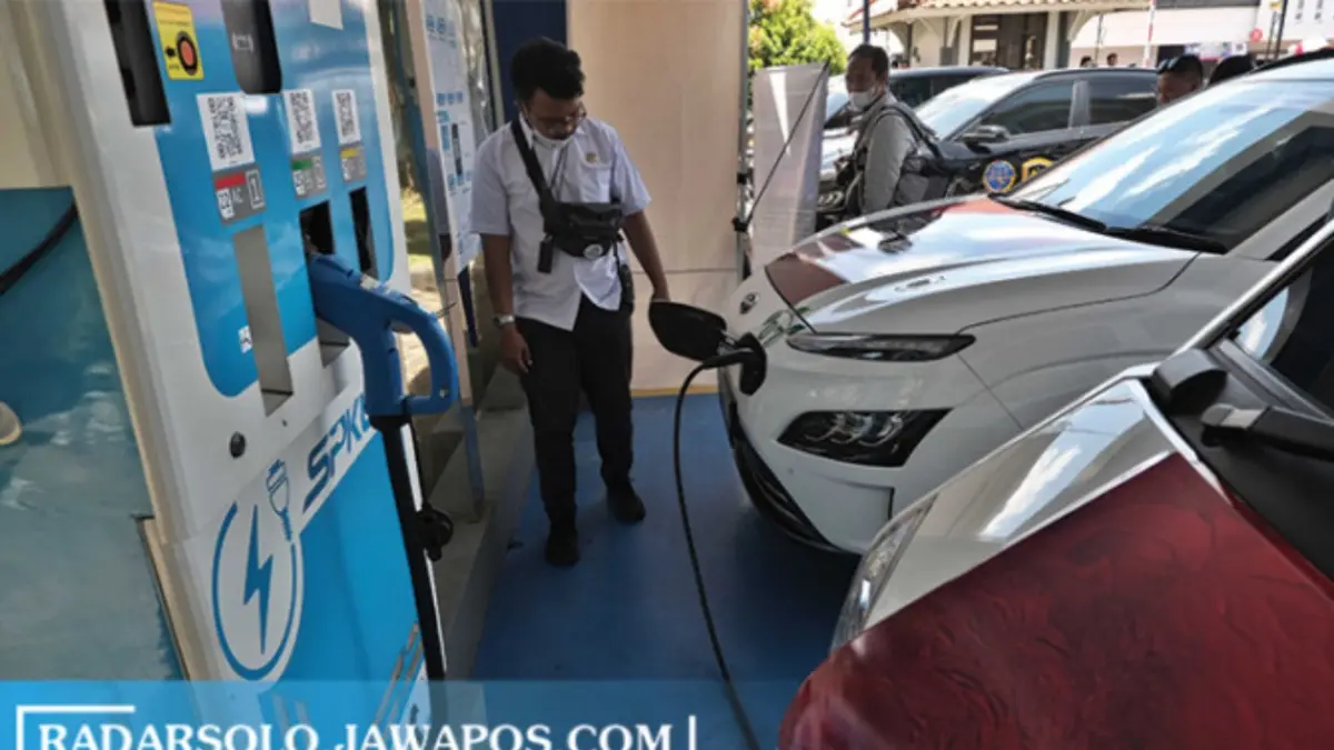 Peserta touring kendaraan listrik tengah mengisi baterai mobil listriknya di SPKLU milik Kantor PLN UP3 Surakarta, Selasa (8/11). Kemenhub menggelar touring kendaraan listrik berbasis baterai start dari Jakarta dan finish di Bali. (ARIEF BUDIMAN/RADAR SOLO)