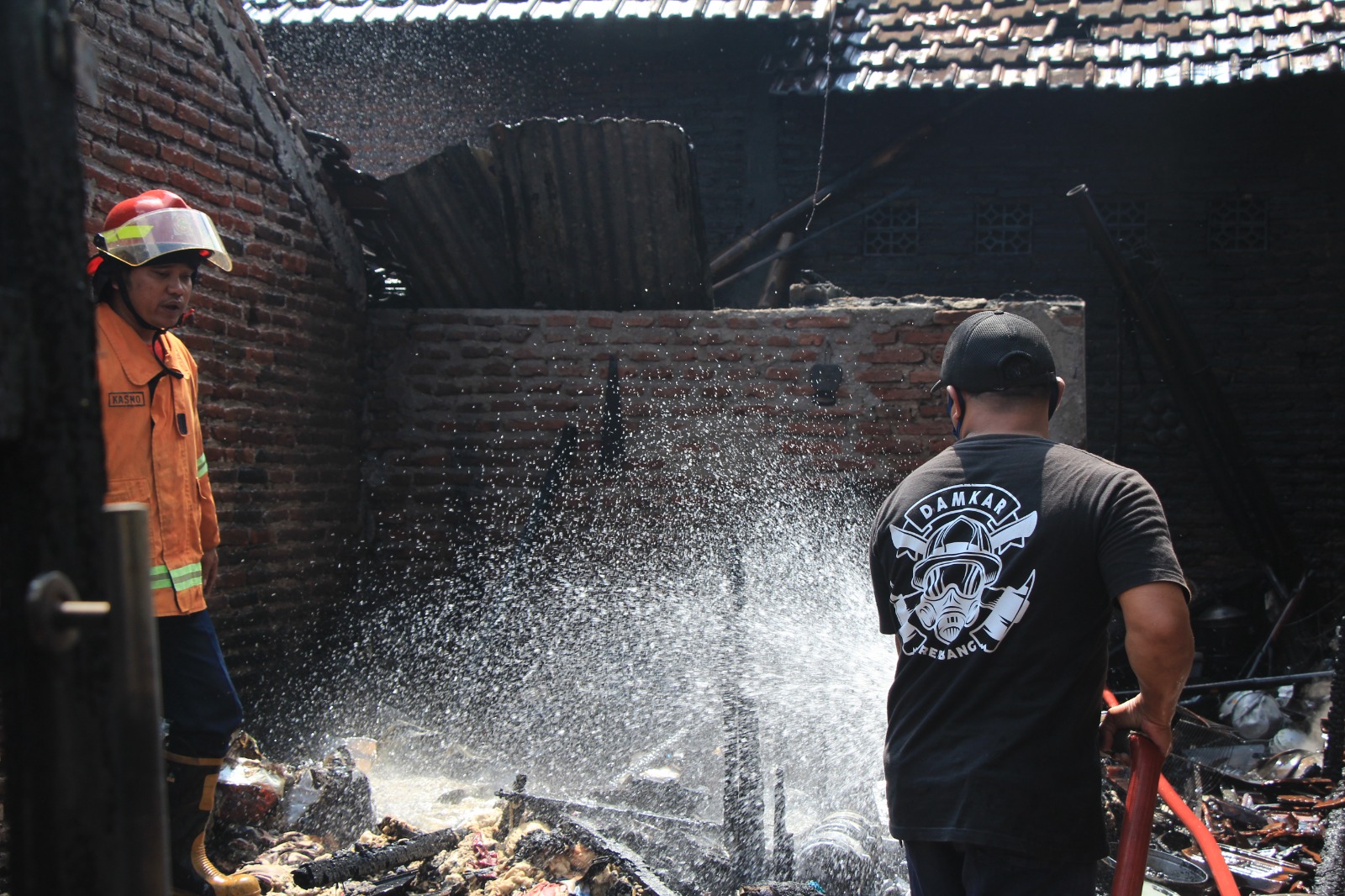 PADAMKAN API: Petugas damkar Rembang berjibaku memadamkan api di rumah mbah Suharsih, warga Mbelik, Sumberjo, Rembangpada Rabu (5/7).