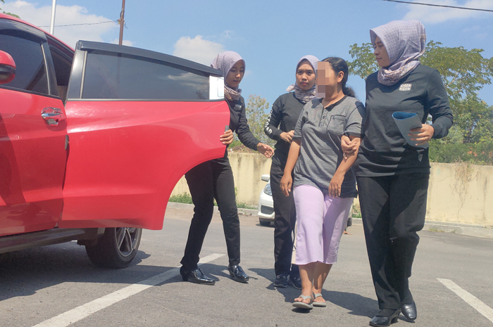 TAK BERKUTIK: Srikandi Polres Rembang mengamankan Naila (dua dari kanan), pedagang pasar yang melakukan investasi bodong jualan seragam kantor batik, Senin (10/7).