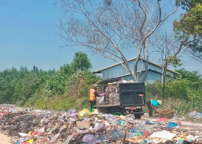 ANGKUT SAMPAH: Seorang petugas mengangkut sampah dari tepi pantai Desa Plawangan, Kragan.