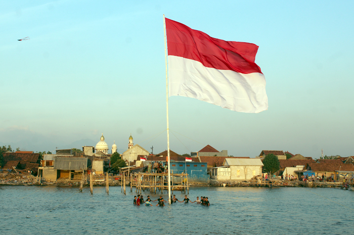KERJA SAMA: Warga Desa Demaan, Jepara Kota, Jepara, bergotong royong mengibarkan bendera merah putih di laut kemarin.