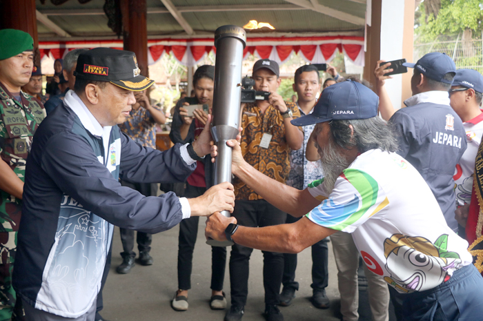 API ESTAFET: Mantan atlet gulat nasional Choirussalim (kanan) menyerahkan api abadi kepada Pj Bupati Jepara Edy Supriyanta di halaman pendapa kabupaten kemarin.
