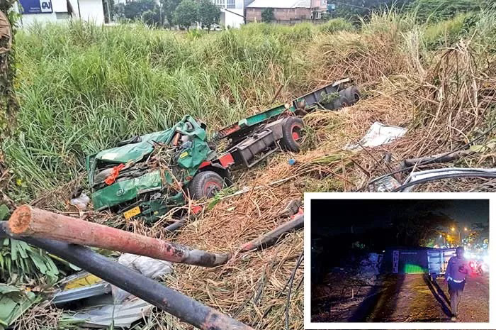 Bangkai truk trailer yang terperosok di Silayur, Ngaliyan. INZET: Petugas melakukan pengamanan jalur Silayur.