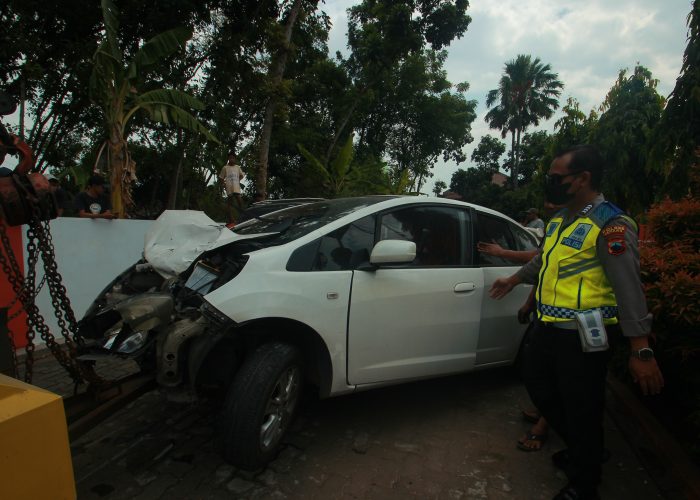 RINGSEK: Polisi memeriksa body mobil Honda Jazz yang terlibat kecelakaan dengan kendaraan atlet Porprov Jateng 2023 sebelum diderek pada Minggu (6/8).