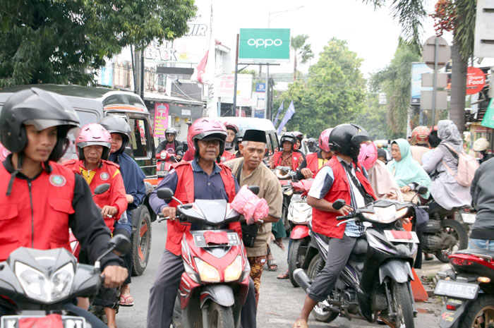 SEMRAWUT: Pengemudi ojek yang melayani peziarah rute Menara Kudus- Bakalankrapyak terlihat kurang tertib mengakibatkan kemacetan.