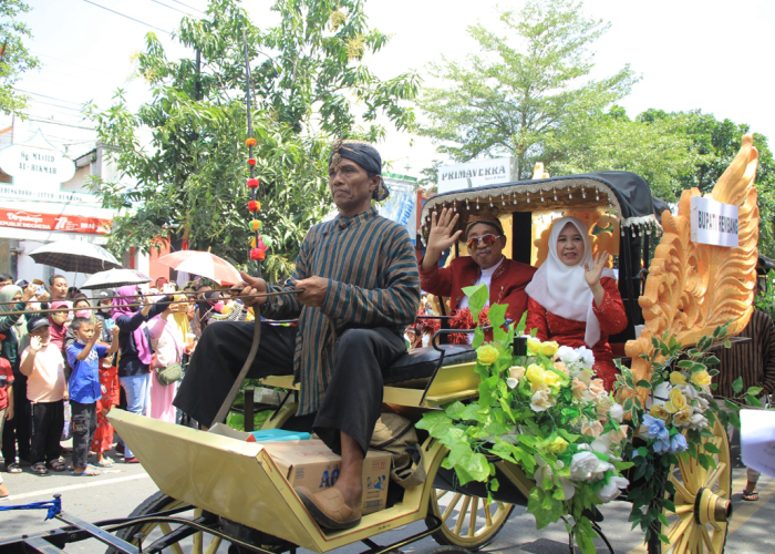 SAPA WARGA: Bupati Rembang Abdul Hafidz bersama istri Hasiroh Hafidz menyapa warga Kota Santri yang menyaksikan kirab budaya tahun 2022.