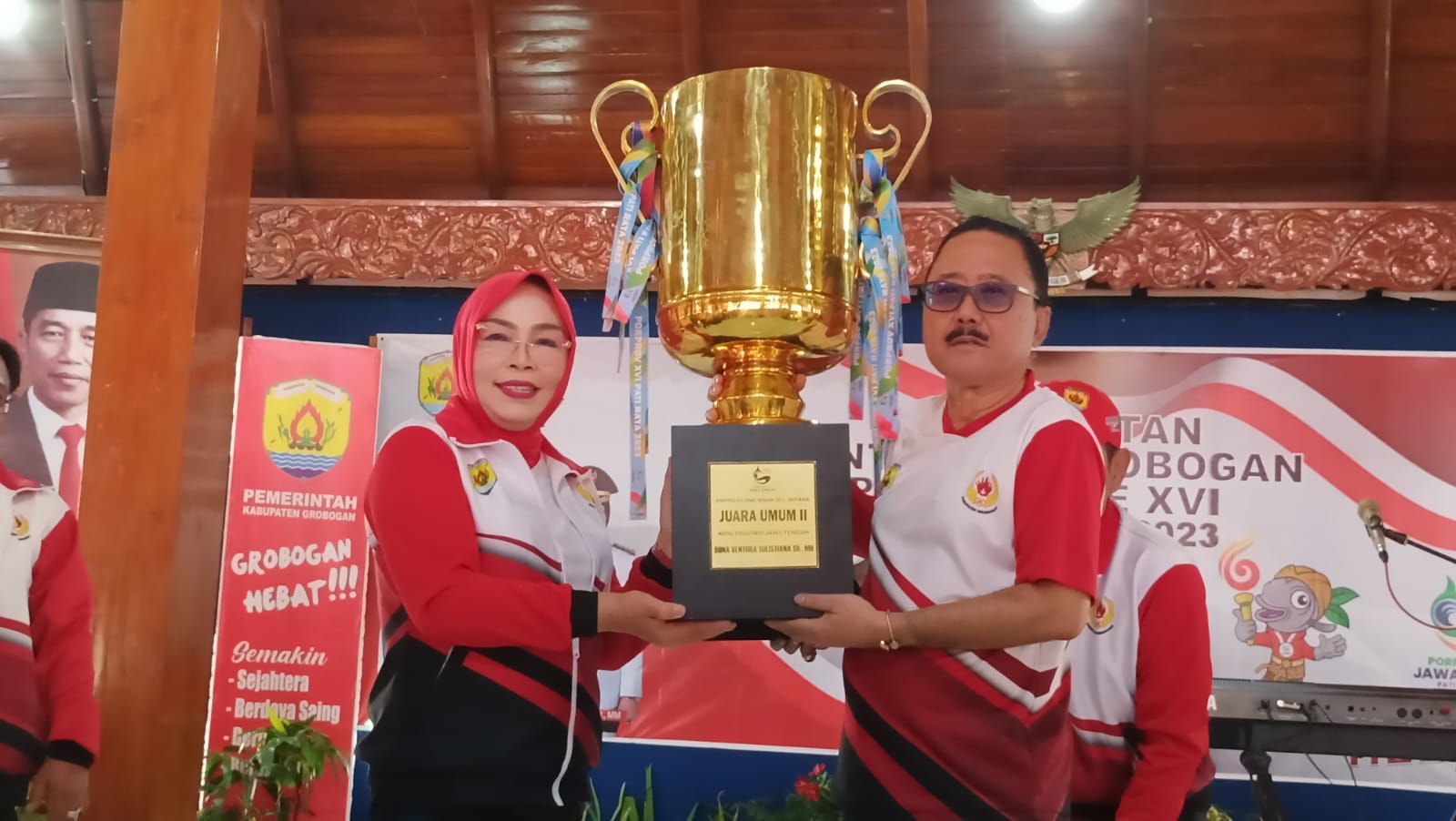RUNNER UP: Ketua KONI Grobogan Fatchurrahman menyerahkan trofi kepada Bupati Grobogan Sri Sumarni di pendapa.