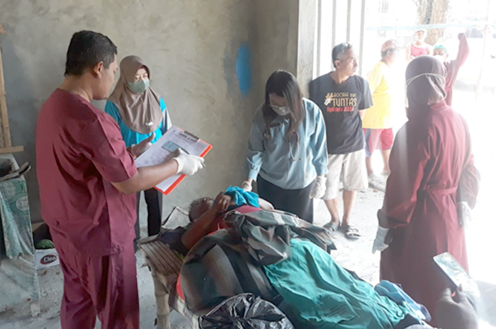 DIEVAKUASI: Petugas evakuasi jenasah penjual arum manis yang ditemukan tergeletak di teras potong rambut di lapangan waru Sabtu (12/8) lalu.