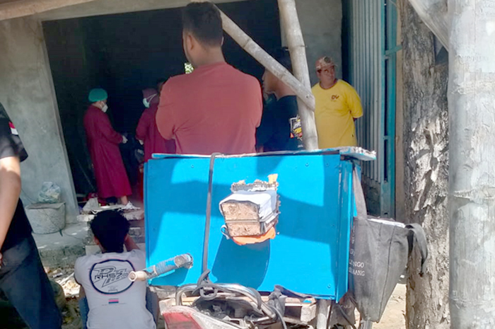 DIEVAKUASI: Petugas evakuasi jenasah penjual arum manis yang ditemukan tergeletak di teras potong rambut di lapangan waru Sabtu lalu.