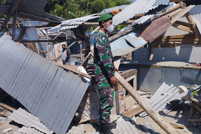 AMBYAR: Petugas Koramil Sluke berada di antara reruntuhan lapak yang atapnya ambyar usai disapu angin puting beliung, Kamis (17/8).
