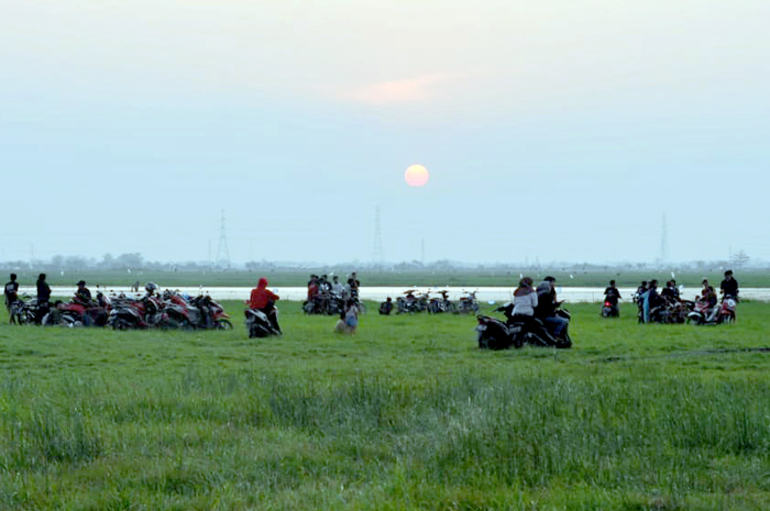 DADAKAN: Warga Margorejo menikmati sunset di lokasi rawa yang mengering di Desa Jambean, Margoyoso kemarin.