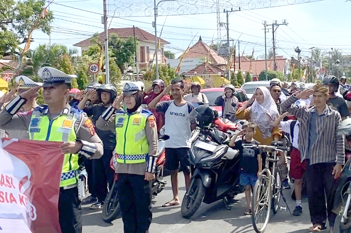 MENYATU: Petugas Satlantas Polres Jepara memperingati detik-detik proklamasi kemerdekaan ke-78 RI di ruas Tugu Kartini bersama pengendara kemarin.