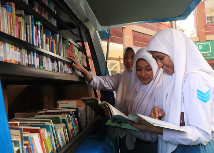 ANTUSIAS: Siswi SMAN 1 Kudus membaca buku di perpustakaan keliling.