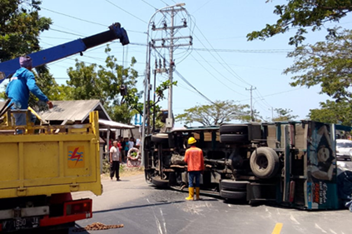 AMBYAR: Petugas Polsek Sluke bersam Satlantas Polres Rembang dan warga bantu evakuasi truk terguling depan Mako Polsek Sluke, Minggu (27/8).