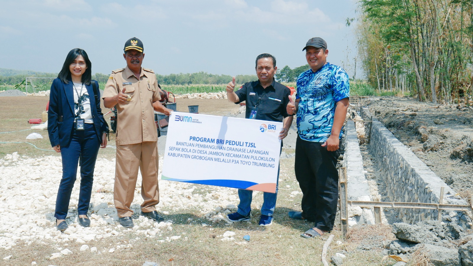 SERAHKAN BANTUAN: Pimpinan Cabang BRI Purwodadi Stefanus Juarto menyerahkan bantuan TJSL untuk pembangunan drainase lapangan Sepak Bola Desa Jambon, Kecamatan Pulokulon baru-baru ini.