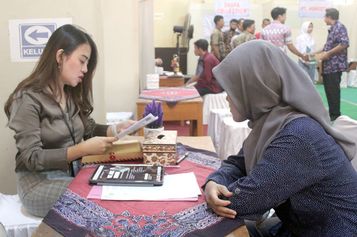 BUKA LOWONGAN: Seorang pegawai perusahaan dari Semarang memeriksa surat lamaran dari pelamar saat jobfair di SMKN 2 Jepara kemarin.