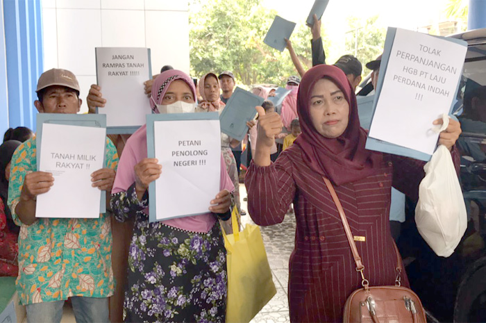 MENGADU: Petani Desa Pundenrejo, Tayu, mengangkat selembar kertas unjuk rasa di Badan Pertanahan Nasional (BPN) setempat belum lama ini.
